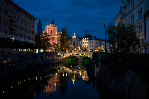 Night descends on the city of Ljubljana, Slovenia. Seen here are the Ljubljanica River, Triple Bridge, the Franciscan Church of the Annunciation, and Preeren Square. (October 20, 2013)