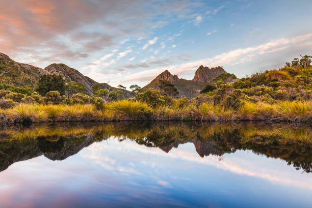 istock Golden mountain range reflected in still lake 1301504167