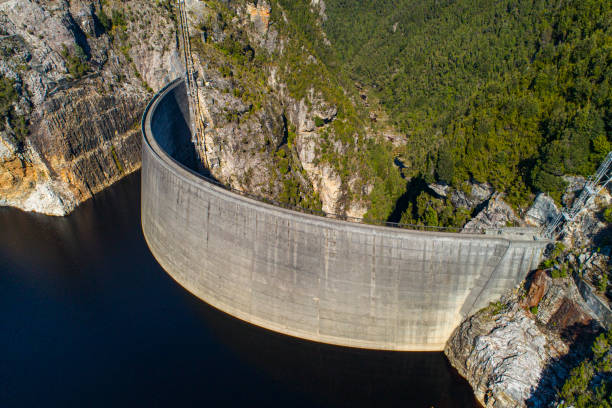 istock Aerial view of large cement dam wall creating hydro electricity 1301504810