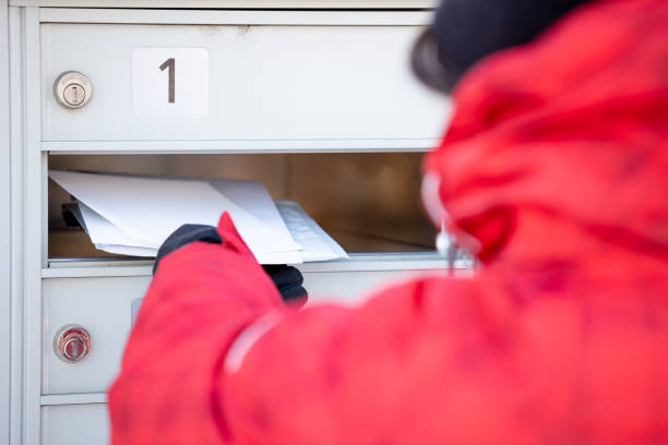 frau trägt handschuhe abholen der post an post-mailbox während der wintersaison - mailbox mail box side view stock-fotos und bilder
