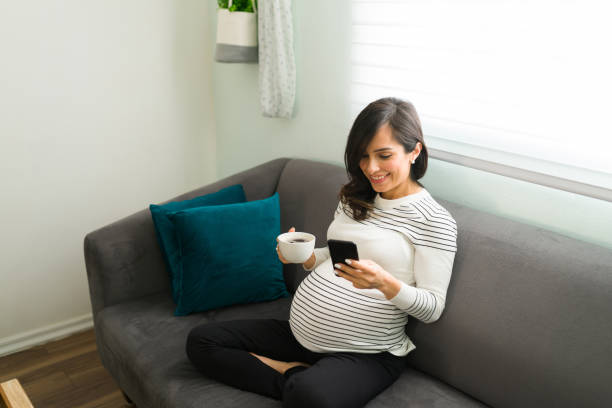 istock Happy expectant mother drinking coffee and sending a text 1301510477