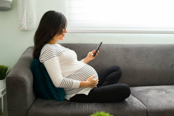 istock Happy expectant mother sending a text message at home 1301510490