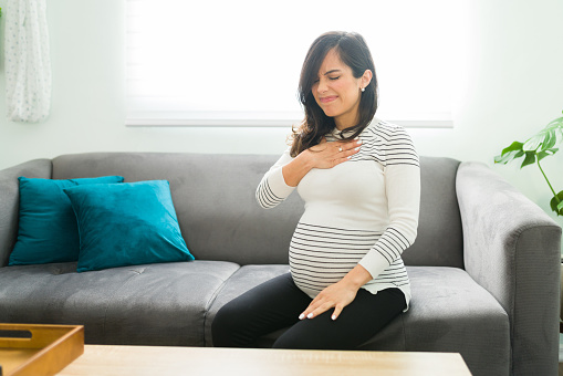 Esposa embarazada que tiene reflujo ácido debido a su embarazo photo