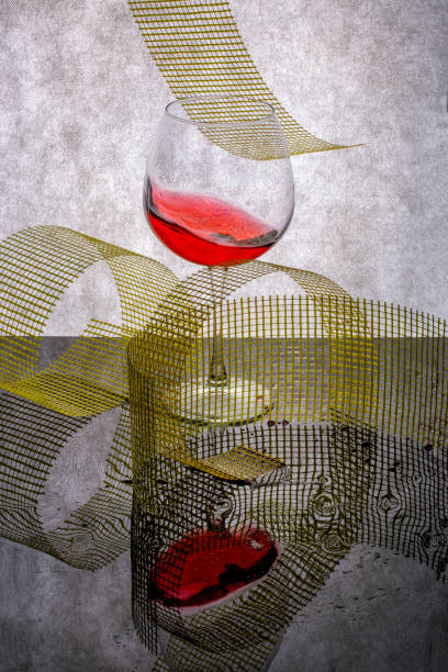 istock Still life with splashed wine in a glass and geometric shapes on a reflective surface 1301513323