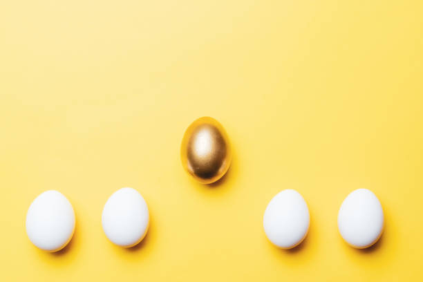 istock Easter card. Golden, white colour egg on pastel yellow background in Happy Easter decoration. Flat lay, top view with copy space. 1301515301