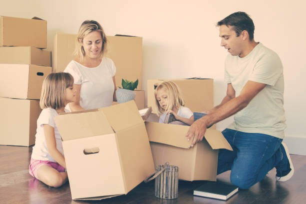 istock Mom, dad and little daughters unpacking things 1301515315