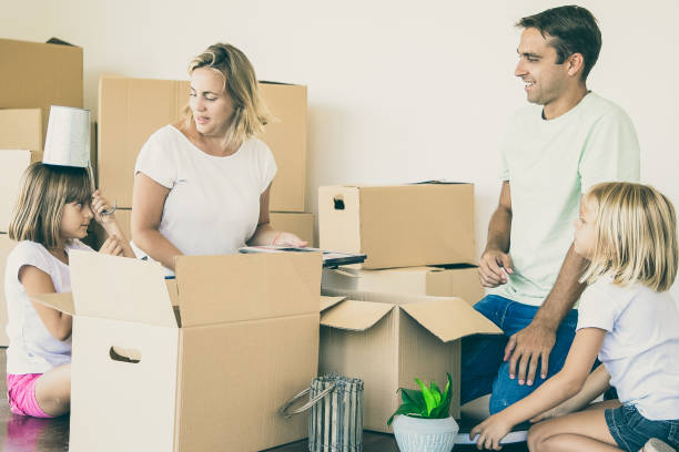 istock Happy parents and little girls having fun while unpacking things 1301516785