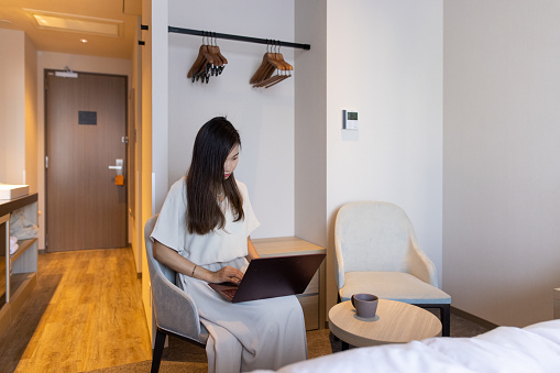 Freelance worker enjoying Bleisure travel in hotel. Working in a guest room, restaurant and common space in the hotel, and taking a break as well. Spending time alone or in a small group in covid-19 situation.