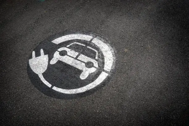 Electric car charging station sign on ground