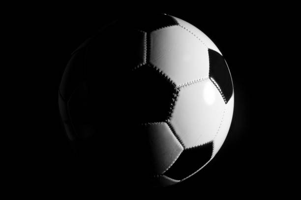 istock Black and white soccer ball on black background 1301520907