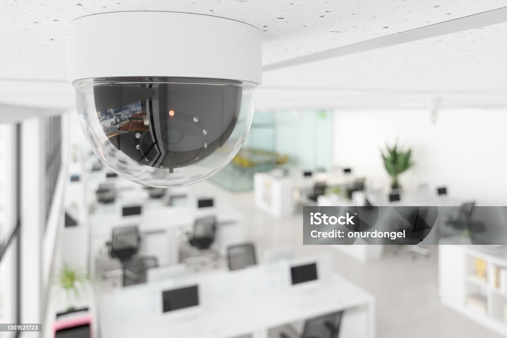 CCTV Camera In Open Plan Blurry Office. Security Camera Stock Photo