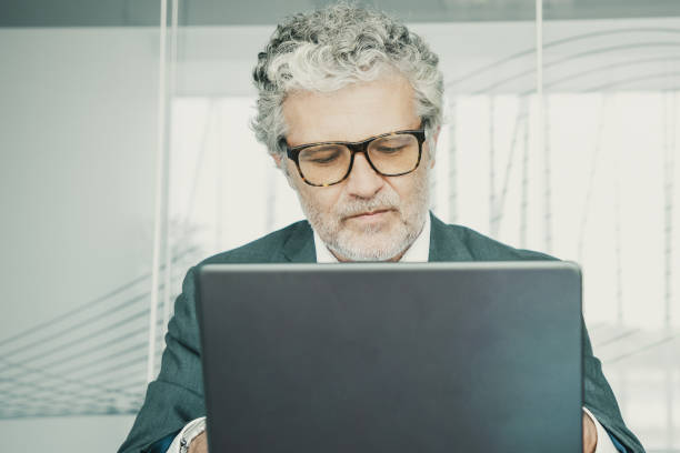 istock Focused mature professional wearing suit and glasses 1301522486