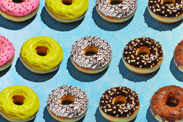 istock Donuts pattern with white, yellow and brown glaze on a blue background 1301523847