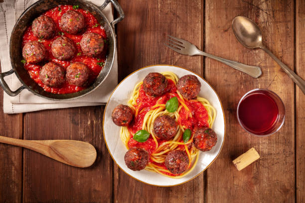 Meatballs with pasta and wine, overhead flat lay shot Meatballs with pasta and wine, overhead flat lay shot on a dark rustic wooden background comfort food stock pictures, royalty-free photos & images