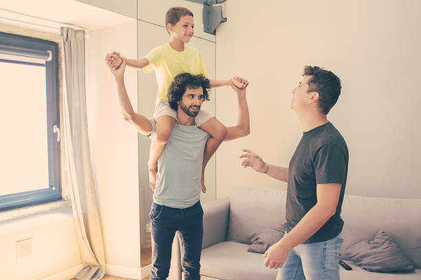 istock Two happy homosexual fathers and son having fun at home 1301525023