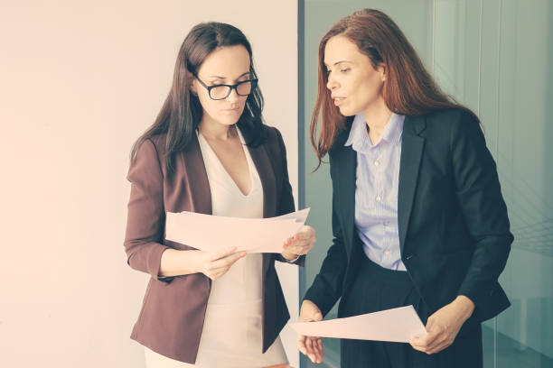 istock Successful female colleagues holding documents, reading report 1301525659