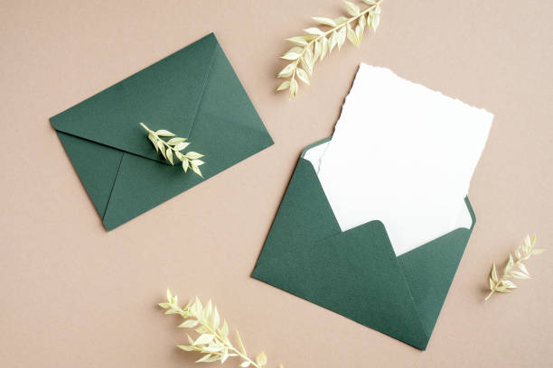 istock Wedding invite mockup and green envelope with dried leaves on pastel beige background. Flat lay, top view, copy space. 1301528403