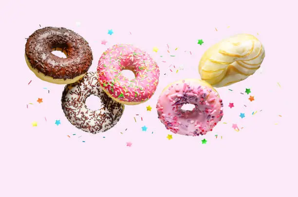 Photo of Flying donuts on a pink background.