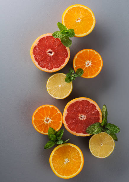 istock Cut in half fresh lemon, grapefruit, orange, tangerine with mint on a gray background, top view 1301532936