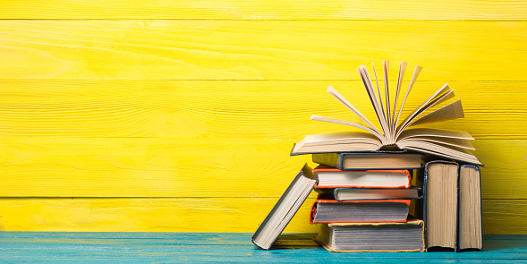 Books On Bookshelf In Library Back To School Education Concept On Colored  Abstract Yellow Background Open Hardback Book Stack In A Raw On Wooden Desk  Table Stock Photo - Download Image Now -