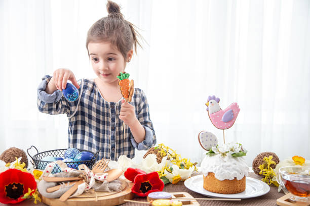 A cute little girl decorates a festive cake for the Easter holiday copy space.