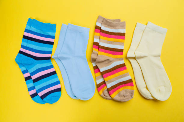 istock Multi-colored socks on a yellow background. View from above. Many different socks for cold seasons 1301536098