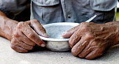 Hungry. Poor old man's hands an empty bowl. Selective focus. Poverty in retirement. Alms