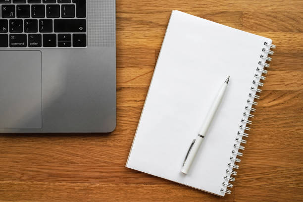 istock Office workplace with a laptop and notepad on a wooden table. Space for text 1301539853