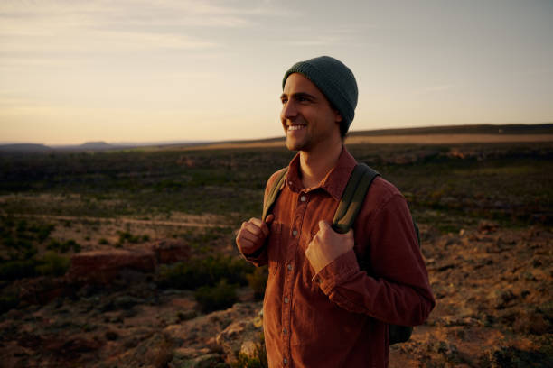 istock Smiling hiker with backpack looking at morning sunrise 1301540810