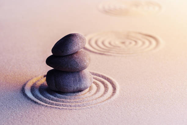 istock Meditation zen garden with stones on sand 1301540842