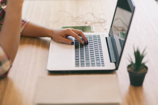 istock Freelancing woman using laptop computer for distance job while sitting in coffee shop. Business woman typing on laptop at workplace Woman working in home office hand keyboard. 1301541033