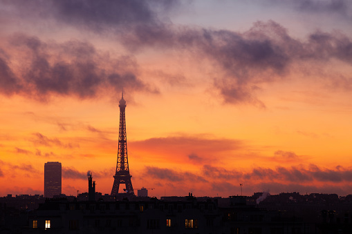 The silhouette of the Eiffel Tower at sunrise over Paris