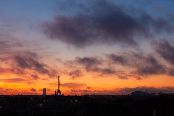 The silhouette of the Eiffel Tower at sunrise over Paris