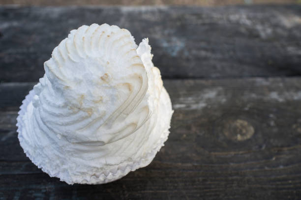 istock Meringue cupcake over dark wooden background 1301544452