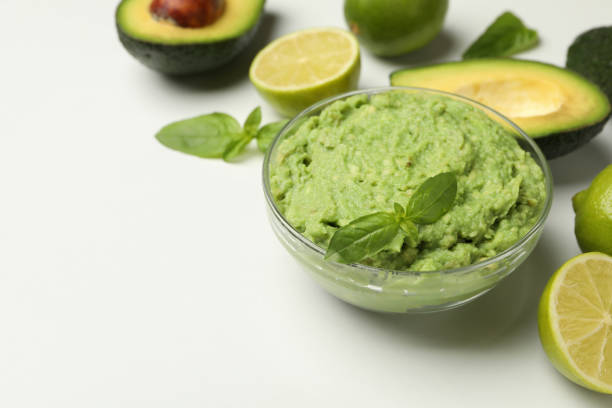 istock Bowl of guacamole, avocado, lime and basil on white background, space for text 1301545718