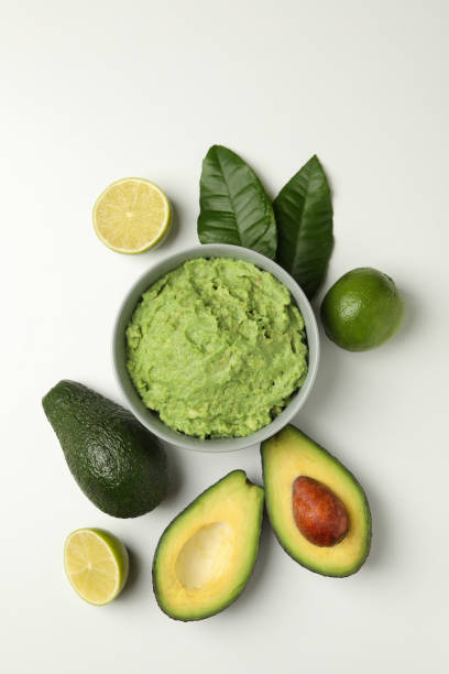 istock Bowl of guacamole, avocado and lime on white background, top view 1301545992
