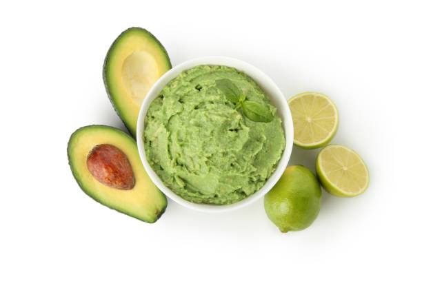 Bowl of guacamole, avocado and lime isolated on white background Bowl of guacamole, avocado and lime isolated on white background guacamole photos stock pictures, royalty-free photos & images