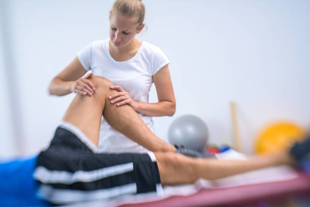 istock Female physiotherapist massaging patient's knee 1301546714