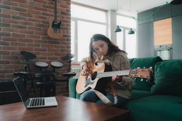 istock Woman watching video lesson on how to play guitar 1301547076