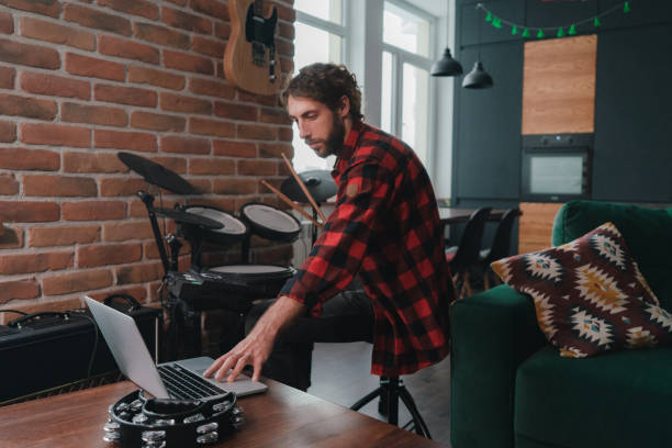 istock Man watching video lesson on how to play drums 1301547332
