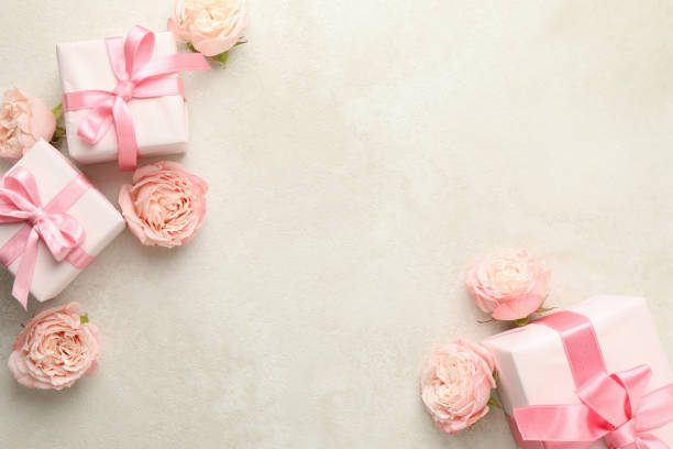 istock Gift boxes and roses on white textured background, space for text 1301547730