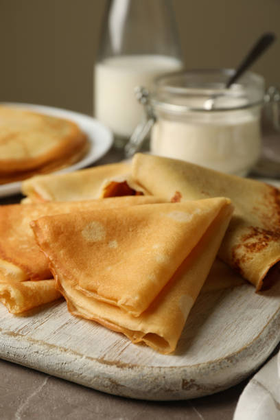 istock Concept of tasty breakfast with thin pancakes on gray table 1301548772