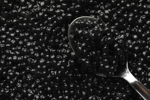 istock Fresh black caviar and spoon on whole background, close up 1301550091