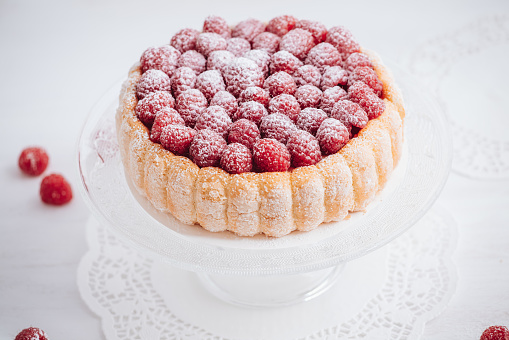 Delicious french Charlotte cake with raspberries and savoiardi biscuits