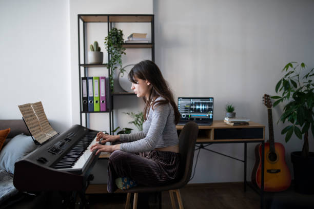 художница, играющая на пианино дома во время карантина. - электропиано стоковые фото и изображения