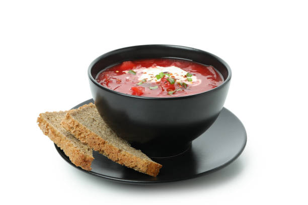 istock Bowl of beetroot soup and bread slices isolated on white background 1301550879