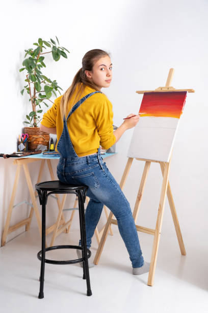 istock Female artist painting in workshop, white background 1301553620
