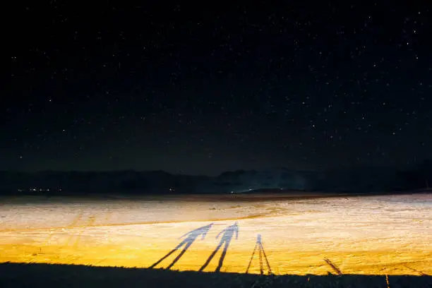 Long exposure photography. A nightshot and the silhouettes of two photographers at night in winter