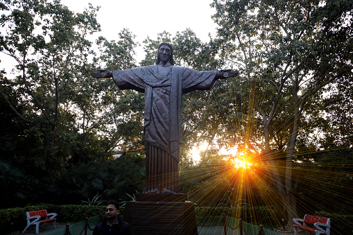 Delhi, India, February 06, 2021 : Christ the Redeemer is an Art Deco statue of Jesus Christ in Rio De Janeiro, Brazil, created by Polish-French sculptor Paul Landowski. wonderful park is built near Sarai Kale Khan Bus terminal Delhi . Replicas of seven great Worlds' Wonders are made of using discarded automobile parts , waste metals and all waste material in a beautiful lovely park.