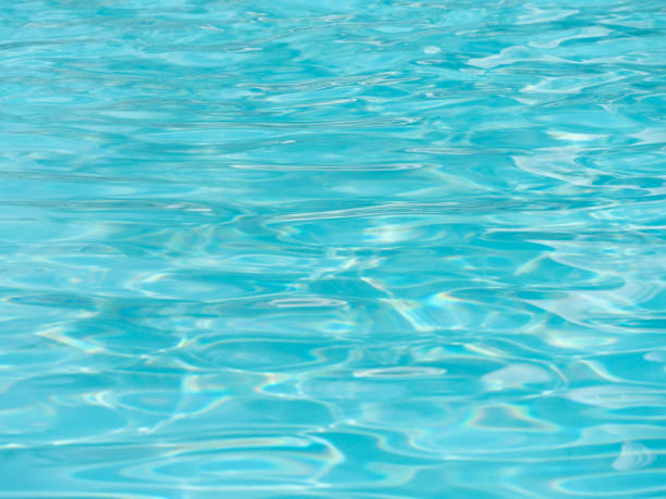 istock Shiny bright blue water surface in the swimming pool with waves. 1301556051
